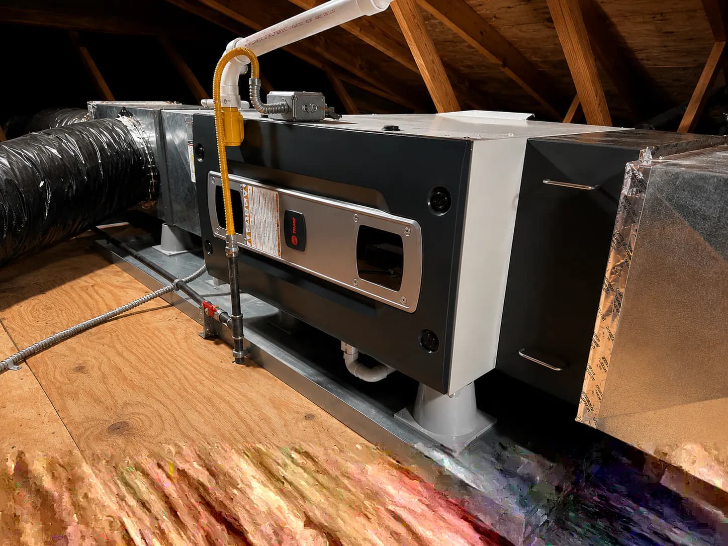 An attic air handler and ductwork in a residential HVAC installation.